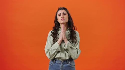Young Caucasian Woman Keeping Her Palms Together and Crossing Fingers Hoping Her Dream Comes True
