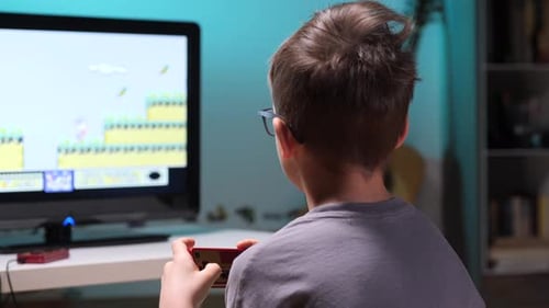 Boy Plays Retro Video Game at Home