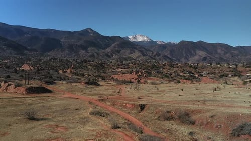 Rising Drone footage over Red Rocks open space, with a view of the snow capped mountains, in Colorad