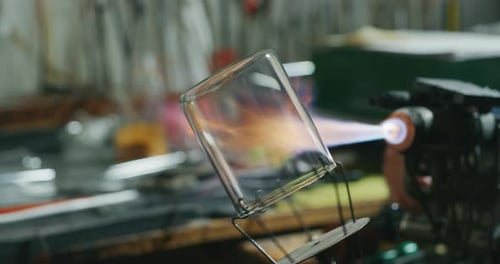 Nahaufnahme eines erfahrenen Glasbläsers in Zeitlupe, der mit Flammen an einem handgefertigten Glas von Preci arbeitet