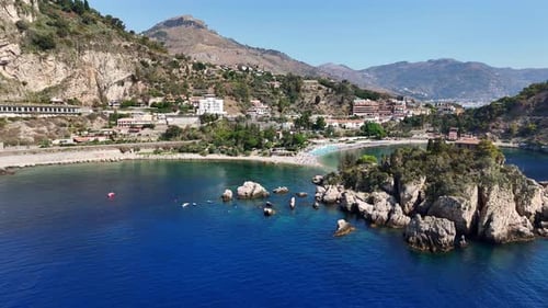 A beautiful coastal town with blue waters and rocky formations, aerial view