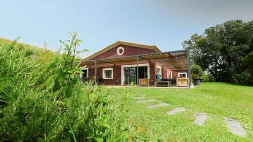 Slow establishing shot of a countryside cabin house in St Colombe