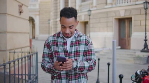 Man Talks on Smartphone on City Street