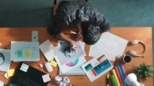 Blick von oben auf den Designer, der bei der Besprechung eine Logografik schreibt und entwirft. Fachtagung.
