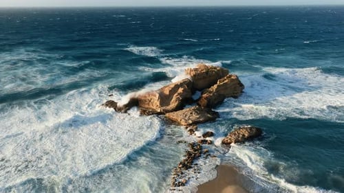 Aerial View of Waves Crashing Rocky Island Coast