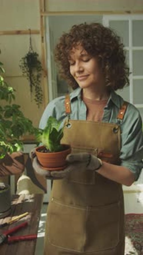 Woman Holding Potted Houseplant at Home Garden, Looking at Camera