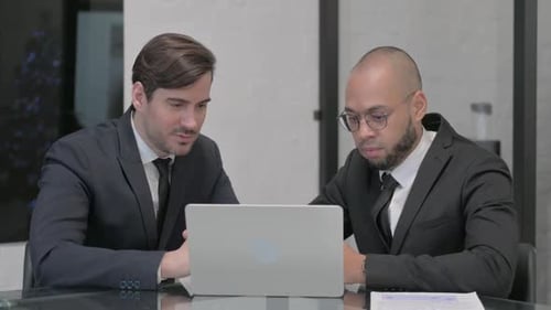 Businessmen Discussing Work on a Laptop