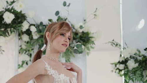Woman Posing in Elegant Wedding Dress Surrounded by Flowers