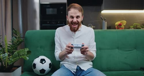 Man Playing Video Game Celebrating Victory at Home