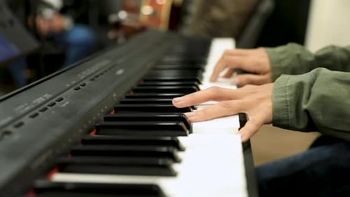 Close-up of female hands playing the piano in the studio
