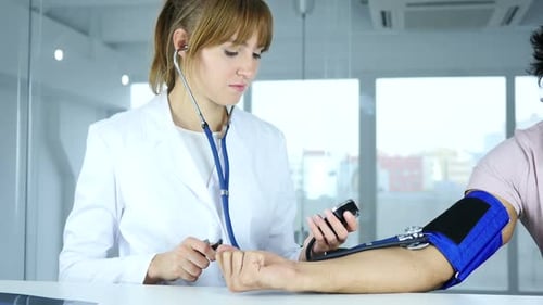 Doctor Checking Blood Pressure of Patient in Clinic