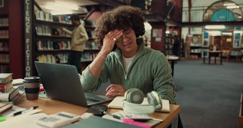 Man, tired and student in library, laptop and stress with deadline for assignment