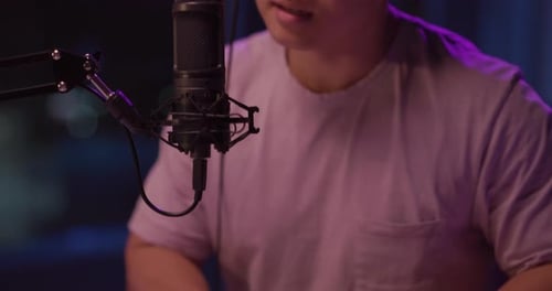 Man Plays Keyboard and Sings into Microphone at Home