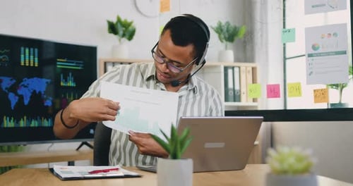 Portrait of man make forecast of trade results studying graphs diagrams with headphones who worker