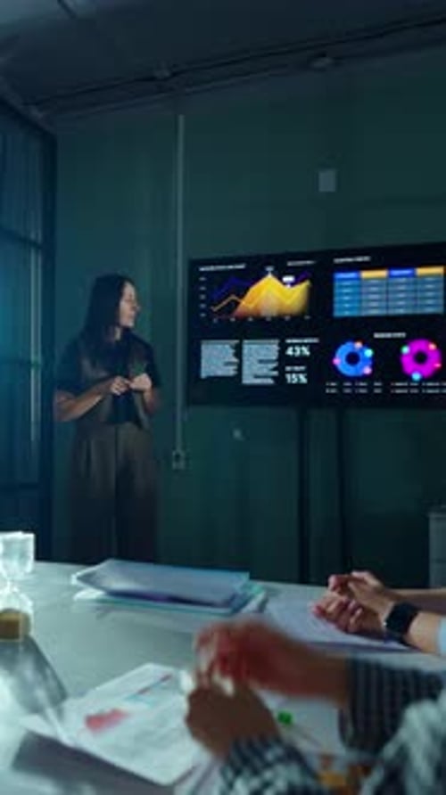 Business Analyst Presenting Digital Charts and Performance Statistics on Large Screen During