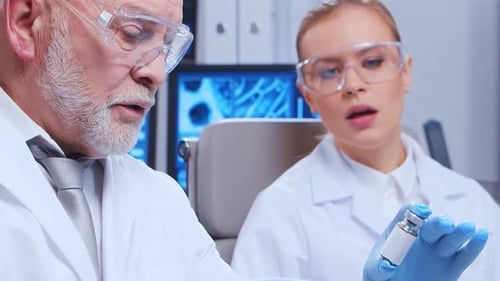 Scientists Examining Vial of Medicine in Lab Setting