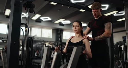 Woman Working Out With Personal Trainer at Gym