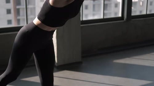 Woman Unrolling Yoga Mat in Sunny Urban Studio