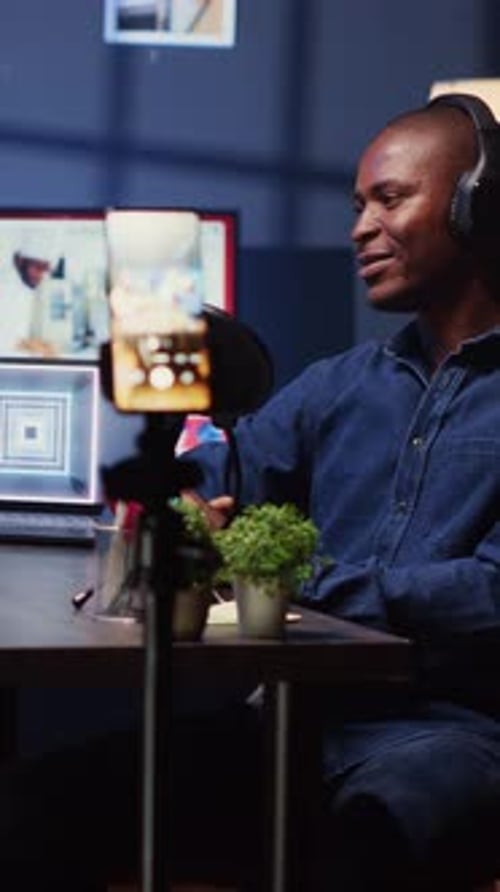 Vertical Video Content Creator Recording Interview with Smartphone on Tripod in Studio Reviewing