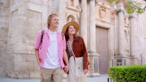 A Joyful Young Couple Enjoying Their Adventure While Exploring an Ancient City Landmark