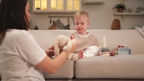 Woman Plays with Child and Toy at Home