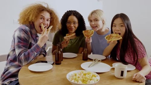 Friends Enjoying Pizza and Beer Together Indoors