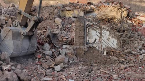 Excavator Demolishing Building at Construction Site