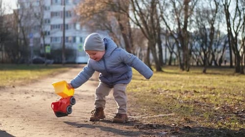 Happy Baby Child Outdoor Little Toddler Boy with Toy Car Having Fun on Walk in Park Baby Son Smiling