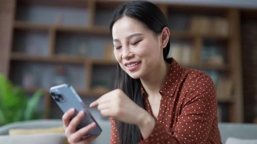Woman Using Mobile Phone Smiling Indoors