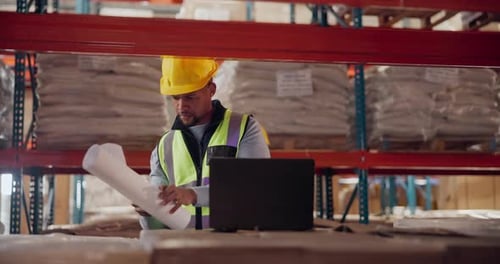 Architecture, man and laptop with blueprint at warehouse planning a building design