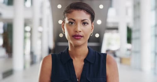 Serious, professional and confident black female standing in a modern office