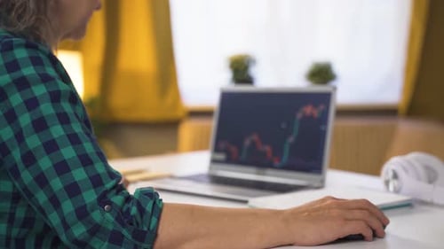 Woman Works at Laptop Displaying Financial Chart