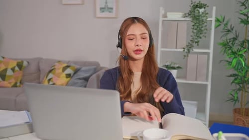 Woman Talking on Headset While Working on Laptop
