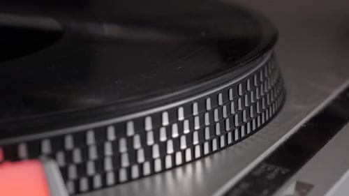 Slow motion of black vinyl record spinning up from start on antique turntable. Close up shot with or