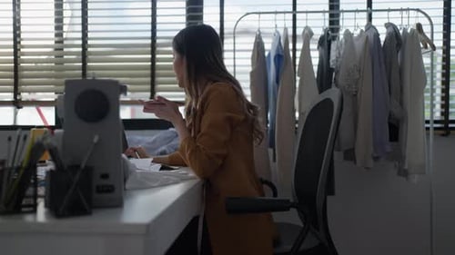 Costureira feminina cortando tecido na linha de desenho, estilista estilista desenhando