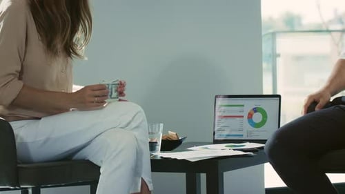 Woman Counting Money and Paying a Man Indoors