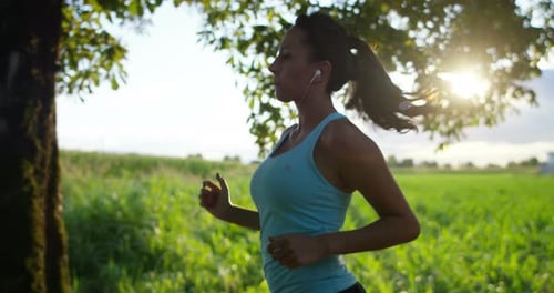 Woman Jogging Through Field on Sunny Day