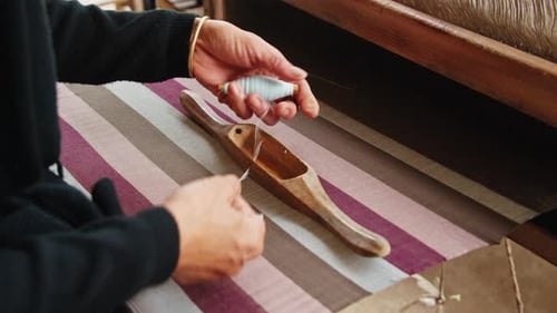 Artisan creates intricate textile patterns using traditional hand-weaving techniques in a workshop