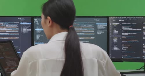Woman Developer Working With Tablet While Write Code With Multiple Screens In Green Screen Studio