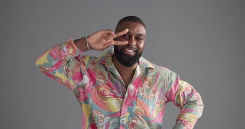 Happy man, funny dancer and face in studio for comedy, humor or moves on a gray background