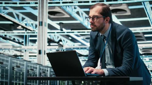 Data Center Admin Typing on Laptop Keyboard Doing Resource Optimization