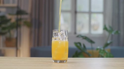 Juice Being Poured Into Glass with Ice