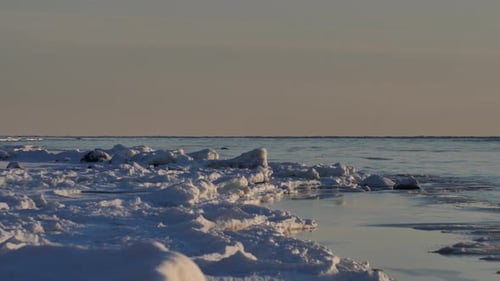 In the winter, stones are icy on the sea shore. Icicles hung from large pieces of ice