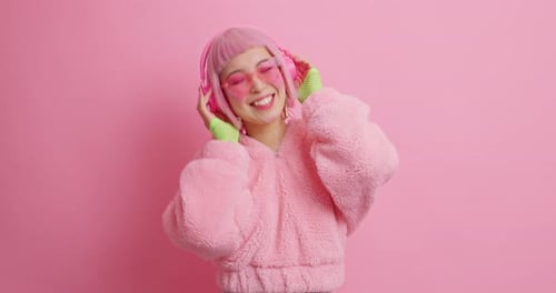 Smiling Woman with Pink Hair Dancing with Headphones