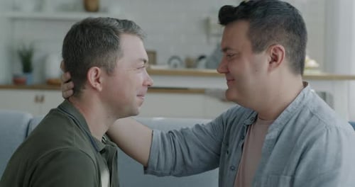 Loving Gay Couple Cuddling on Couch Together