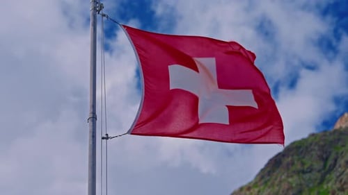 Swiss Flag Waving in Wind in Mountainous Area