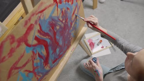 Artist Painting with Brush on Easel