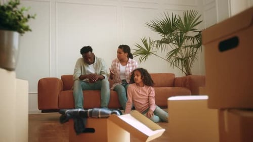 Family Discusses Their New Home While Unpacking Boxes in an Apartment