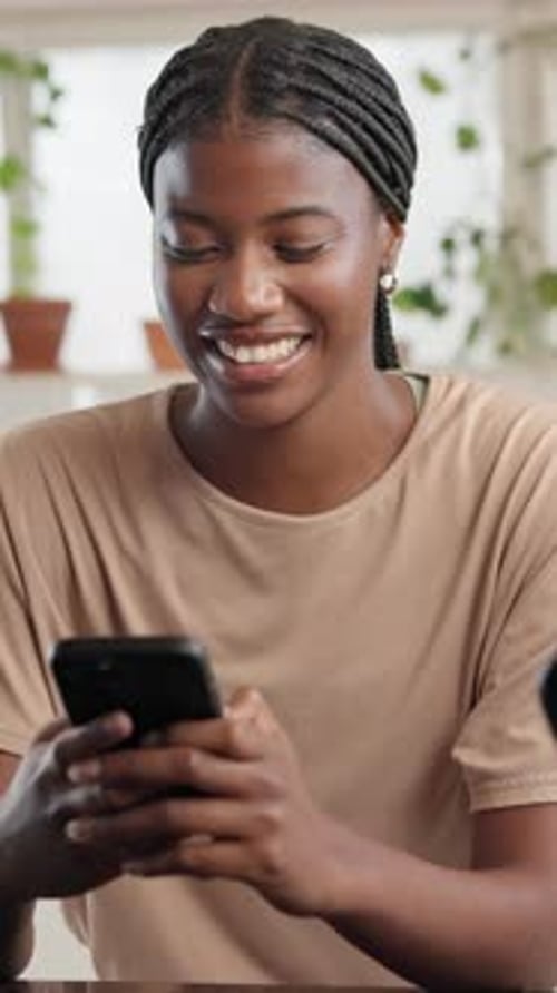 Smiling woman using phone inside