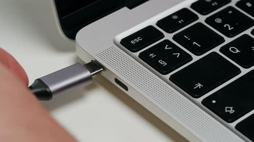 Charging Connection to Laptop on White Table Closeup Phone Charging Port USB Wire for Devices